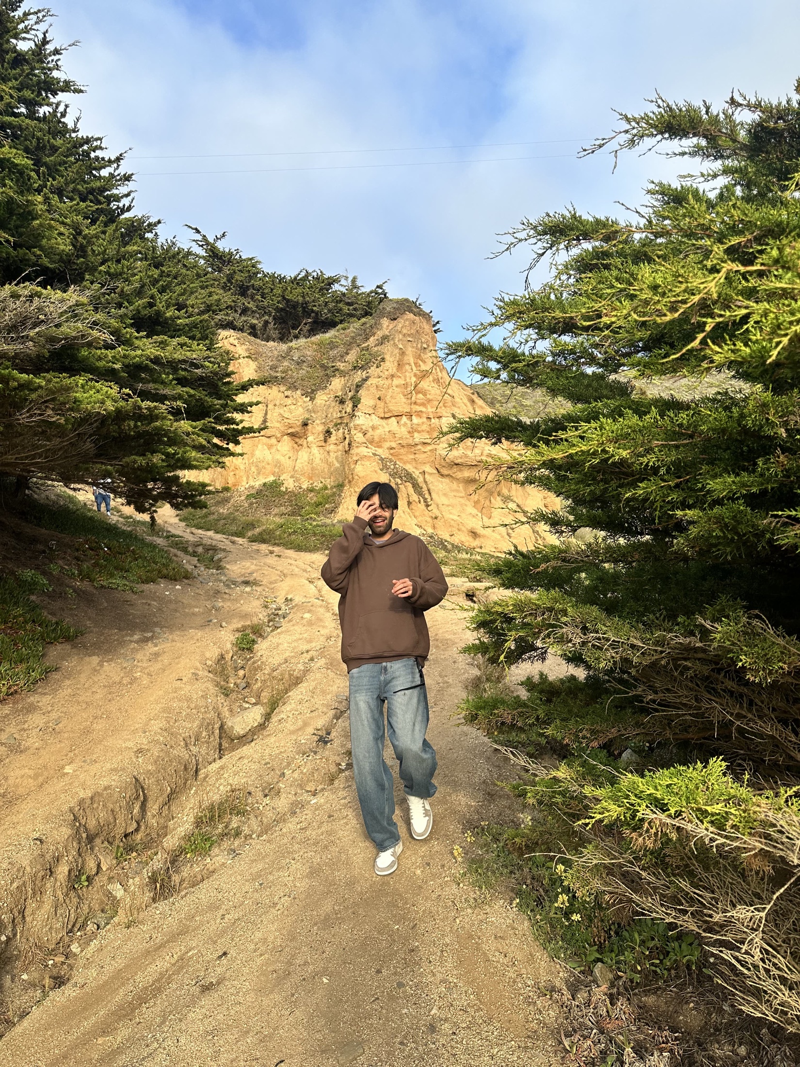 Kartikeya walking on a sandy trail between trees
