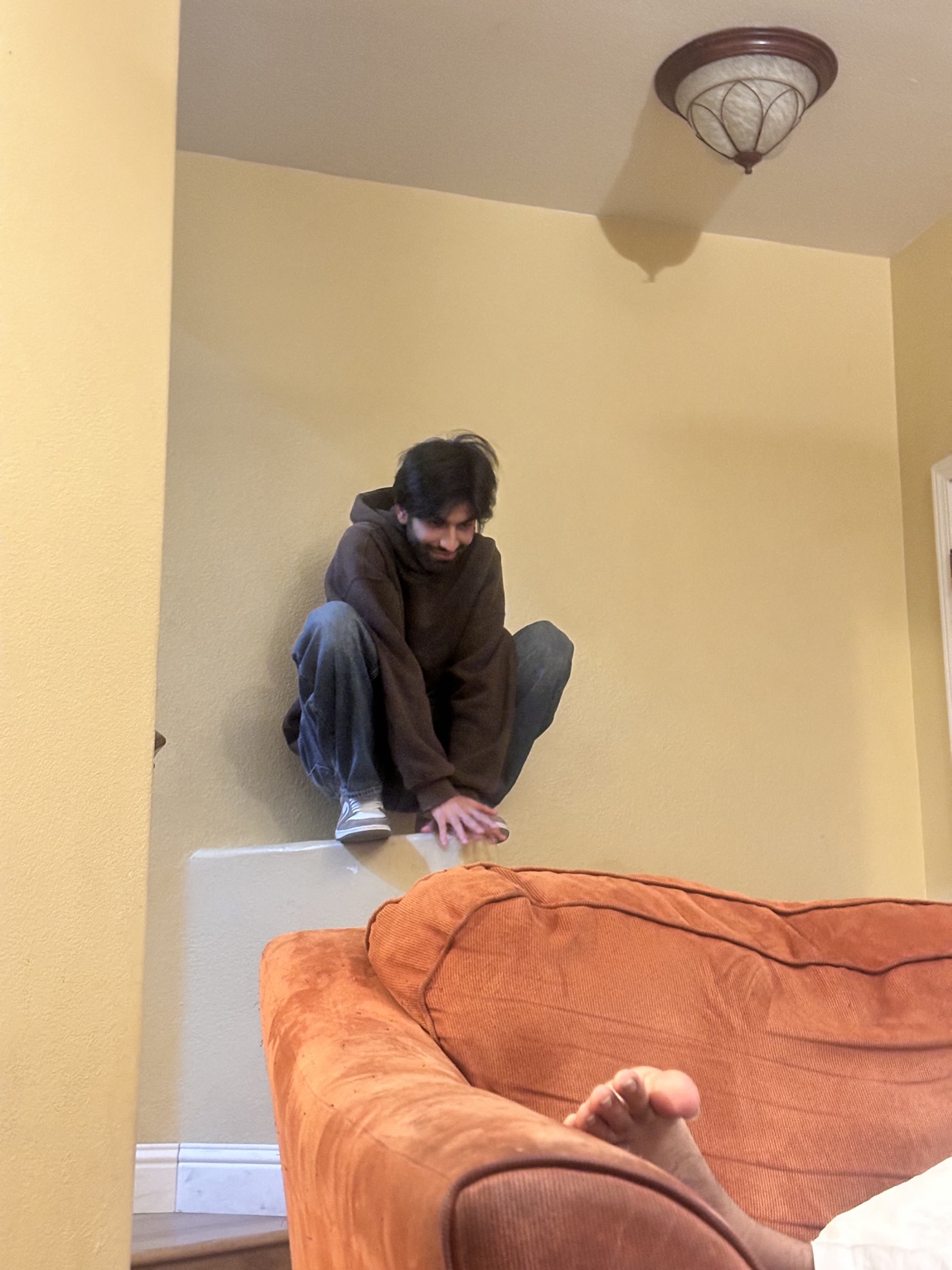 Kartikeya crouched on furniture in a room