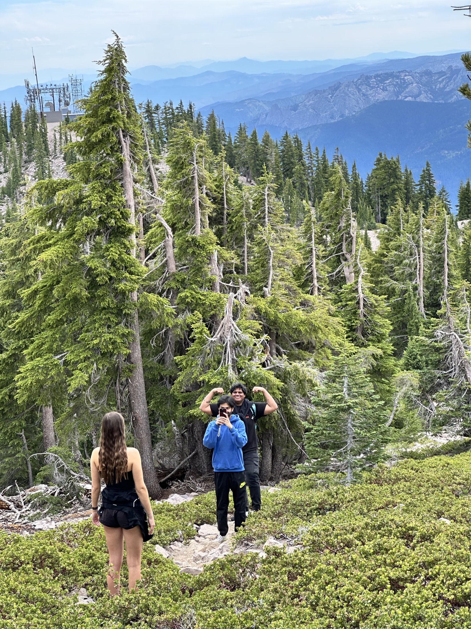 Two people hiking through a green mountain path