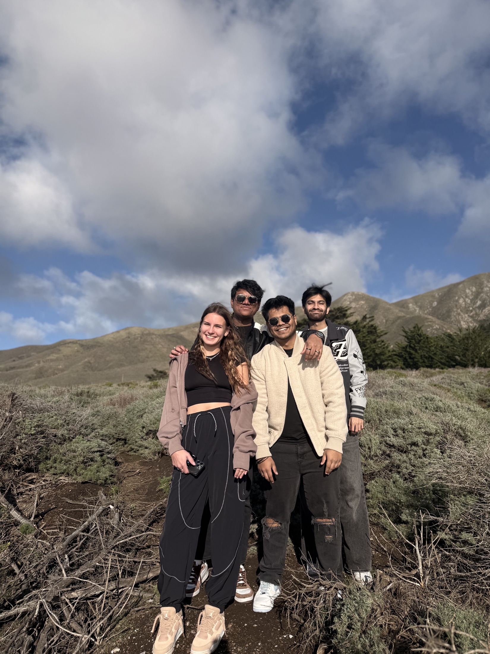 A group of friends posing on a windy hillside