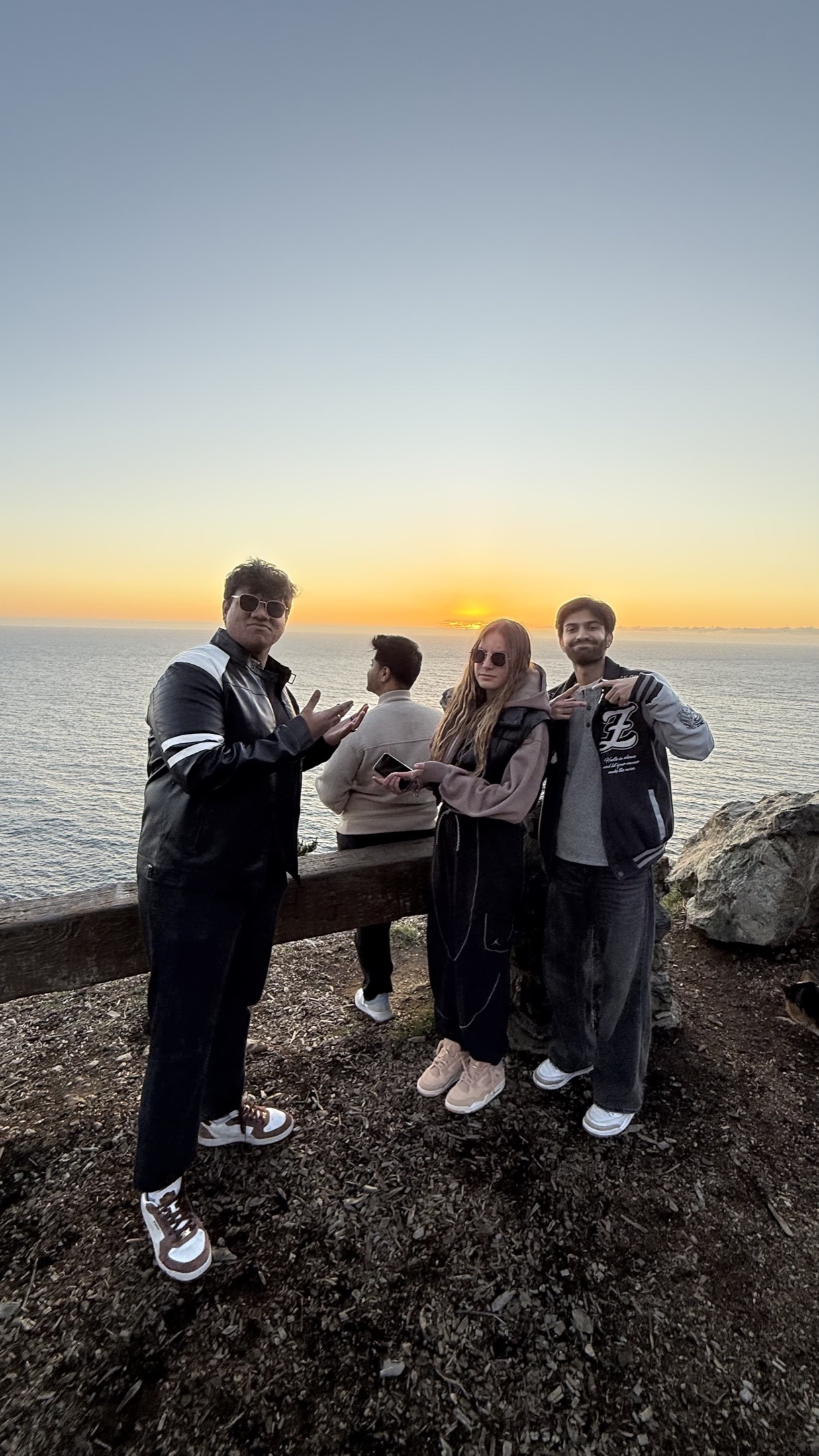 Friends gathered at sunset on a cliff