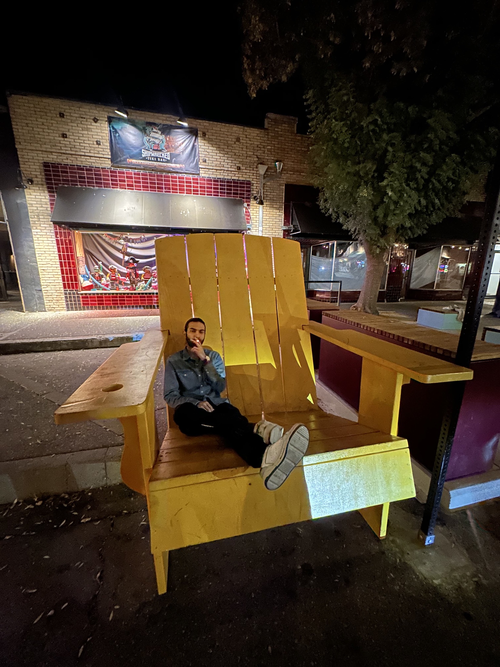 Kartikeya sitting on a giant yellow chair at night